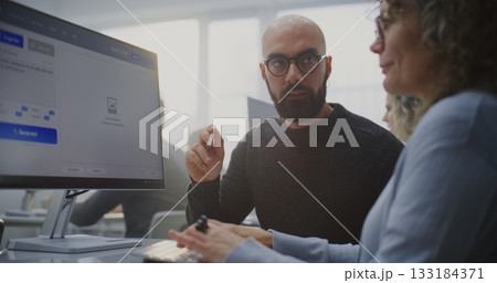 In Modern Computer Lab, Young Teacher Demonstrates Adult Student How Write Prompts For AI Generate In Modern Computer Lab, Young Teacher Demonstrates Adult Student How Write Prompts For AI Generate 133184371