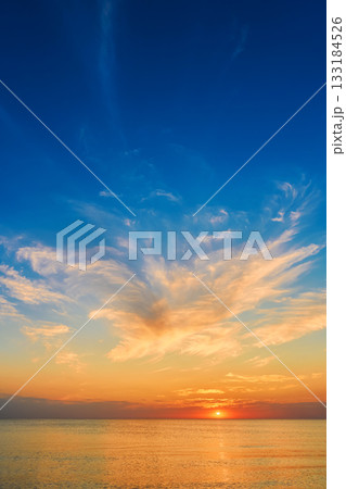 Vertical poster with the sun at sunset, calm sea and warm autumn evening, velvet season on the coast of a warm sea, copy space for advertising autumn vacations Vertical poster with the sun at sunset, calm sea and warm autumn evening, velvet season on the coast of a warm sea, copy space for advertising autumn vacations 133184526