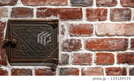 Cast iron inspection hatch for checking devices on a brick wall, loft-style interior, vintage-style design with space for copying 133184534