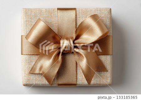 Seasonal gift. Gold box wrapped with a bow on white background. Jewelry, birthdays, Christmas and luxury branding. Seasonal gift. Gold box wrapped with a bow on white background. Jewelry, birthdays, Christmas and luxury branding. 133185365