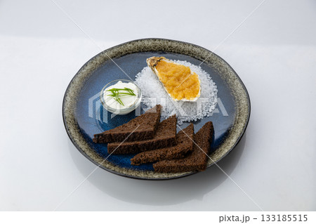 Oyster with caviar, rye toasts and sour cream on black plate, top view Oyster with caviar, rye toasts and sour cream on black plate, top view 133185515