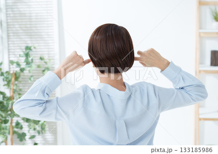 騒音から耳を塞ぐ女性 133185986