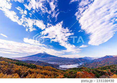 【山梨県】ダイナミックな雲、カラマツの黄葉の向こうに富士山 133186430