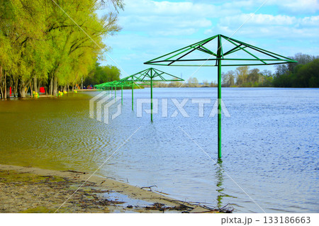 Empty beach awnings flooded with water during flood of spring Empty beach awnings flooded with water during flood of spring 133186663