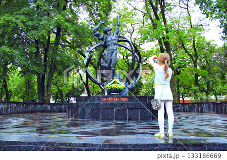 Little girl making photo by smartphone of Chernobyl monument. Ukrainian tragedy 133186669