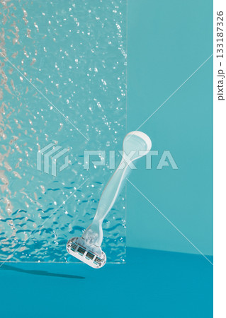 Minimalist elegance: Razor in sharp relief against a bold blue backdrop with dramatic shadows 133187326