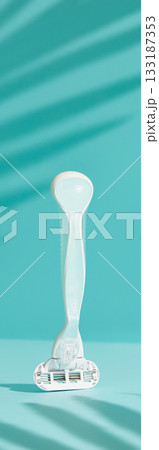 Minimalist elegance: Razor in sharp relief against a bold blue backdrop with dramatic shadows Minimalist elegance: Razor in sharp relief against a bold blue backdrop with dramatic shadows 133187353