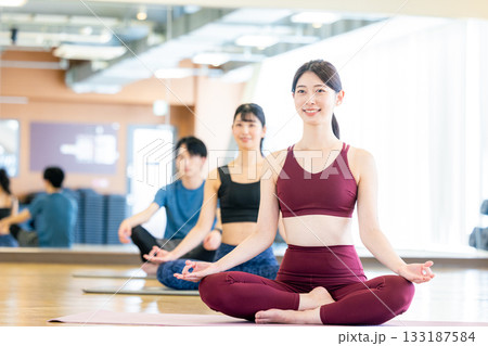 ヨガスタジオでヨガをする若い男女 ヨガスタジオでヨガをする若い男女 133187584
