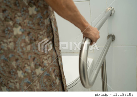 Asian elderly woman patient use handrail safety in toilet support rail in bathroom. Asian elderly woman patient use handrail safety in toilet support rail in bathroom. 133188195