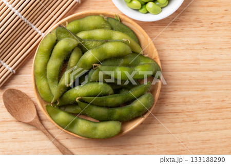 Boiled Edamame beans (Japanese soybeans) on wooden background, Table top view Boiled Edamame beans (Japanese soybeans) on wooden background, Table top view 133188290
