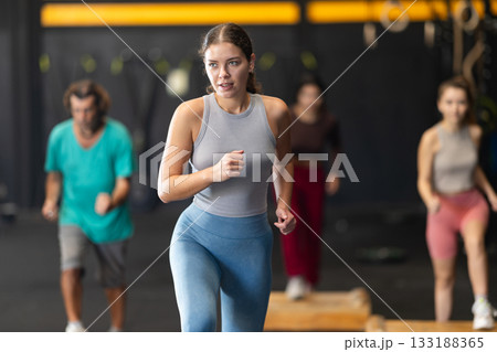 Young woman stepping on box at Crossfit workout Young woman stepping on box at Crossfit workout 133188365