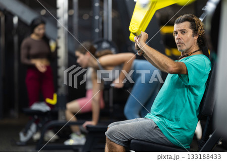 Determined middle-aged man training upper body muscles Determined middle-aged man training upper body muscles 133188433