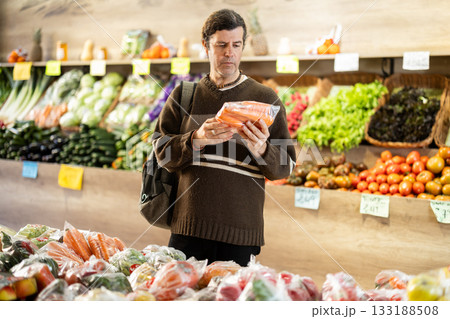 Adult man choosing carrots in plastic bag 133188508