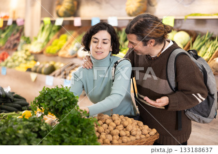 Couple man and woman choosing parsley in vegetable shop Couple man and woman choosing parsley in vegetable shop 133188637