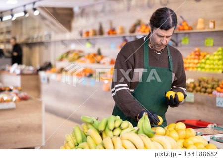 Adult woman seller puts lemons on display 133188682