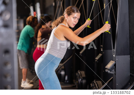 Woman doing exercises on ski ergometer simulator Woman doing exercises on ski ergometer simulator 133188702