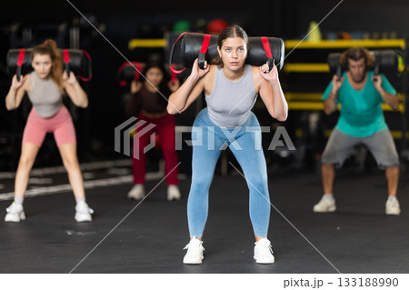 Young woman doing exercises with a bag in the gym 133188990