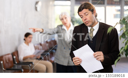 Upset adult man with documents in office Upset adult man with documents in office 133189018