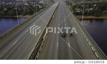 Aerial view of motorcycle riding on highway bridge. Clip 133189318