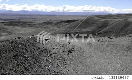 Lone hiker exploring vast desolate landscape. Media Lone hiker exploring vast desolate landscape. Media 133189457