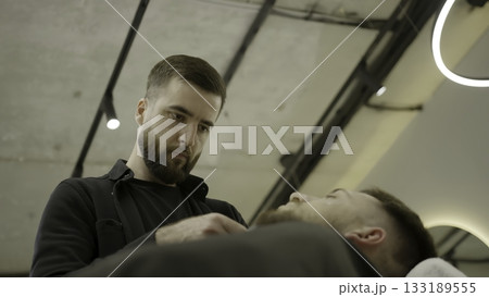 Barber giving a precise haircut with a trimmer. Clip 133189555