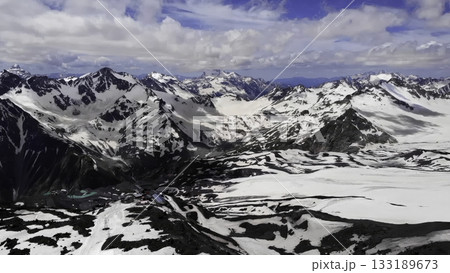 Dramatic clouds moving over snowy mountain range 133189673