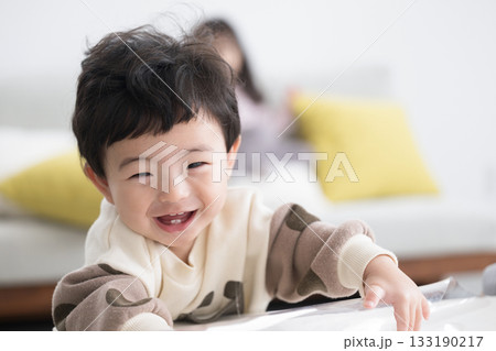 つかまり立ちする赤ちゃんのかわいい カメラ目線 かわいい乳歯の萌出 つかまり立ちする赤ちゃんのかわいい カメラ目線 かわいい乳歯の萌出 133190217