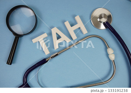 TAH abbreviation of Total Abdominal Hysterectomy alphabet letters with magnifying glass and stethoscope on blue background 133191238