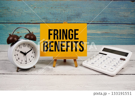 Fringe Benefits text written on paper card with calculator and alarm clock on wooden background Fringe Benefits text written on paper card with calculator and alarm clock on wooden background 133191551
