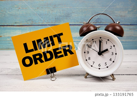 Limit Order text written on paper card with alarm clock on wooden background Limit Order text written on paper card with alarm clock on wooden background 133191765