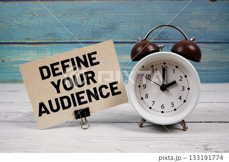 Define Your Audience text written on paper card with alarm clock on wooden background Define Your Audience text written on paper card with alarm clock on wooden background 133191774