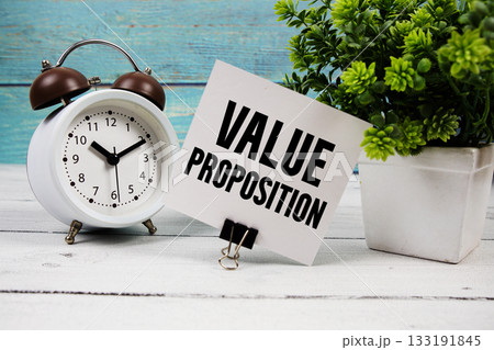Value Proposition text written on paper card with alarm clock on wooden background 133191845