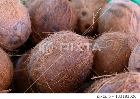 Discovering the rustic charm of fresh coconuts at a vibrant market stall on a sunny afternoon 133192020