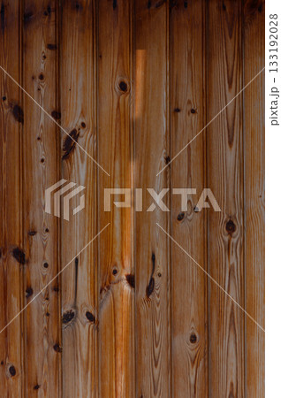Close-up view of rustic wooden planks showcasing natural patterns and textures under warm light Close-up view of rustic wooden planks showcasing natural patterns and textures under warm light 133192028
