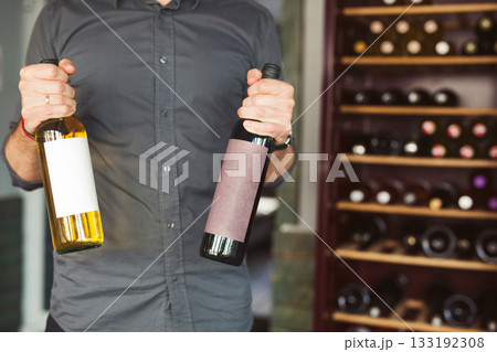 Man is going to buy red, white wine in liquor store. 133192308