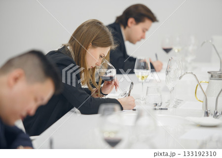 Sommelier association during wine tasting, wine school. Wine waiters degustates various alcohol beverages on training. Blind wine tasting. 133192310