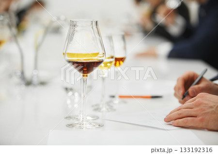 Blind tasting, close up. Sommelier makes notes on the tasting card.  133192316
