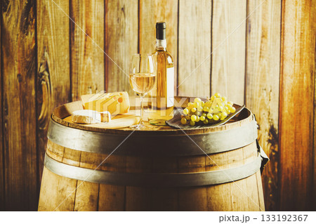 white wine on barrel with grape and cheese on background of wooden wall. 133192367