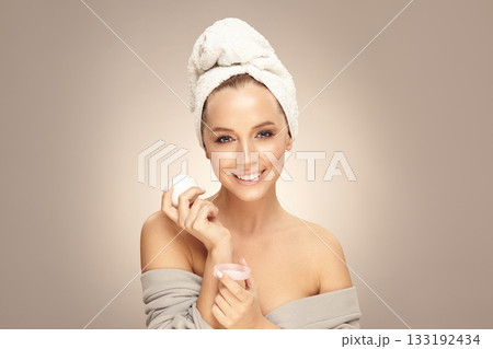 Female beauty model after a shower holds near her face natural eco safety cream on beige isolated, close up portrait with free copy space. Female beauty model after a shower holds near her face natural eco safety cream on beige isolated, close up portrait with free copy space. 133192434