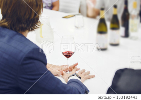 Sommelier looking at holding red wine glass, analysis it color, scrutiny taste and tartness of alcoholic drink, faceless pov shot. Man takes part in lecture on production and history of wine origin. 133192443