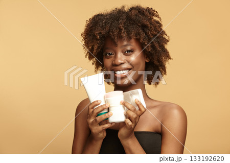 Beautiful girl shows plastic tube, round, square jars mockups. 133192620
