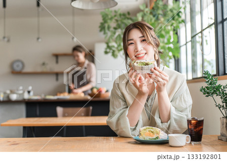 カフェのランチ・ブランチ・朝食でサンドイッチを食べるアジア人女性 133192801
