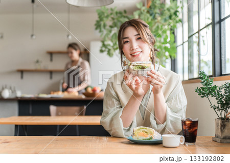 カフェのランチ・ブランチ・朝食でサンドイッチを食べるアジア人女性 133192802