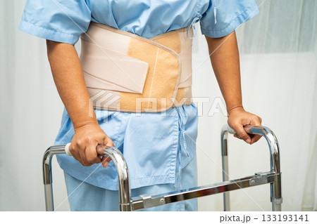 Asian senior pain back wearing elastic support belt with walker. Asian senior pain back wearing elastic support belt with walker. 133193141