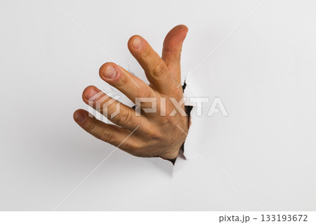 Hand emerging from a wall hole creating a surprising visual effect Hand emerging from a wall hole creating a surprising visual effect 133193672
