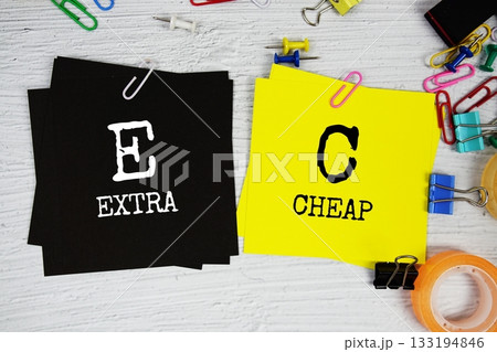 EC - Extra Cheap text on stick note with stationery on concrete background 133194846