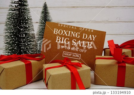Festive display with small decorative Christmas trees and gift box present with "Special Offer Boxing Day Big Sale up to 60% off, Promotion Holiday Sale Event 133194910