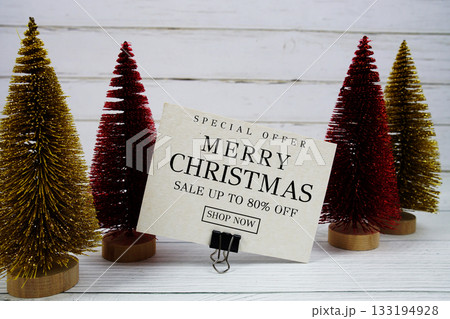 Festive display with small decorative Christmas trees with "Special Offer Merry Christmas Big Sale up to 80% off, Promotion Holiday Sale Event 133194928
