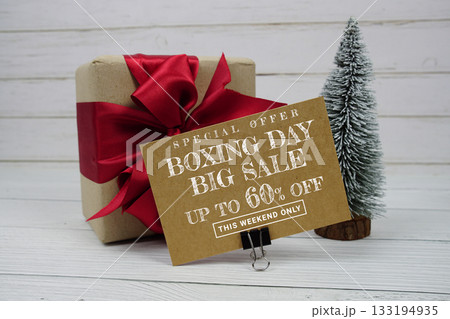Festive display with small decorative Christmas trees and gift box present with "Special Offer Boxing Day Big Sale up to 60% off, Promotion Holiday Sale Event 133194935