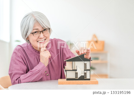 住宅模型を持つグレイヘアーのシニア女性（家づくり,注文住宅,マイホーム) 133195196